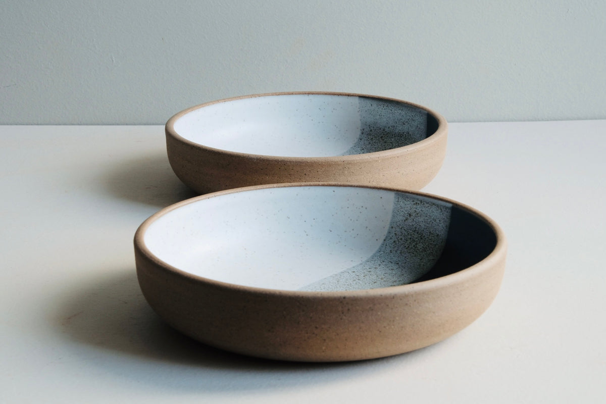 two low bowls with black and white layered glaze
